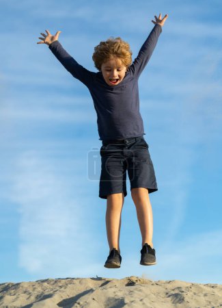 Téléchargez les photos : Portrait d'un enfant garçon dans la nature, dans un parc ou à l'extérieur. Gros plan du visage d'un enfant heureux jouant à l'extérieur dans un parc d'été - en image libre de droit