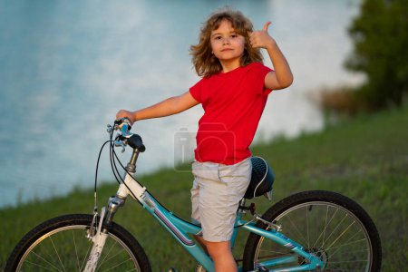 Photo for Little kid boy ride a bike in the park. Kid cycling on bicycle. Happy smiling child riding a bike. Boy start to ride a bicycle. Sporty kid bike riding on bikeway. Kids bike - Royalty Free Image