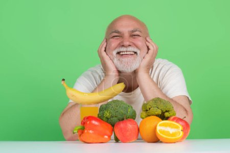 Photo for Senior drink near fruits and vegetables in studio. Elderly man on fruits and vegetables diet. Vegetables and Healthy Fruit for aged people. Healthy lifestyle. Aged Fruit Vegetables Dieting - Royalty Free Image