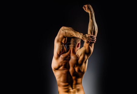 Foto de Cuerpo muscular. Hombros y músculos de la espalda. Muscular Man showing his Strength, Back view. Cuerpo sexy. Hombros y espalda fuertes. Atleta Muscular de Detrás Mostrando Espalda Músculos. Fuerte y sexy - Imagen libre de derechos
