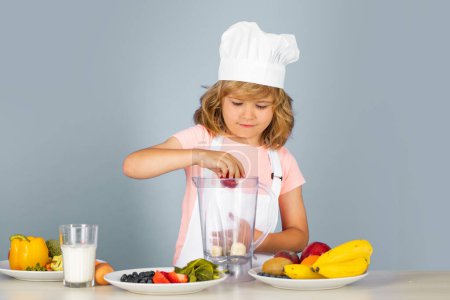 Photo for Cooking children. Chef kid boy making fresh smoothie for healthy eat. Portrait of little child in form of cook isolated on grey background. Kid chef. Cooking process - Royalty Free Image