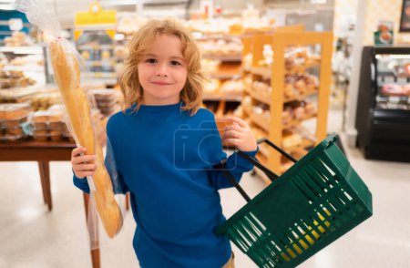 Foto de El niño está eligiendo verduras y frutas frescas en la tienda. Niño comprando comida en el supermercado. Comprando en la tienda de comestibles. Abarrotes en el supermercado - Imagen libre de derechos