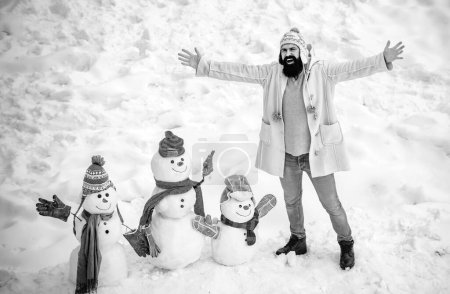 Photo for Merry Christmas and Happy Holidays. Christmas preparation - funny bearded man make snowman. Snowman and funny bearded man in the snow - Royalty Free Image