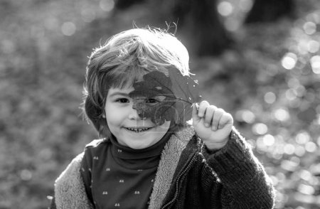 Foto de Otoño niños, precioso niño jugando en el parque de otoño - Imagen libre de derechos