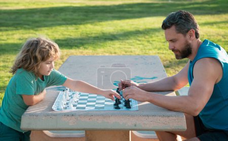Foto de Padre e hijo jugando ajedrez pasando tiempo juntos en el parque. Niño jugando juego de mesa con los padres. A los hombres les gusta el ajedrez. Retrato de generación masculina - Imagen libre de derechos