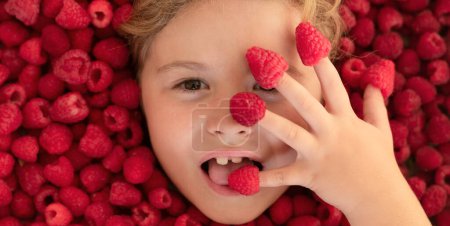 Photo for Summer fruits. Cute little girl eats raspberries berries. Kid eating vitamins. Close up face - Royalty Free Image