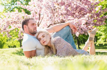 Jóvenes casados enamorados disfrutando de la hermosa naturaleza de primavera. Hermosa pareja joven disfrutando del jardín floreciente. Citas de hombre y mujer, San Valentín y ternura