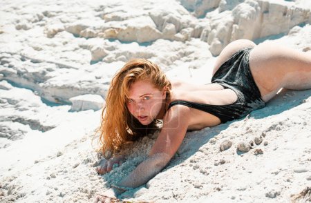 Téléchargez les photos : Sexy belle femme couchée dans le sable sur la plage. Vacances au Paradis. Femme de sable sur la plage de sable. Corps d'été - en image libre de droit