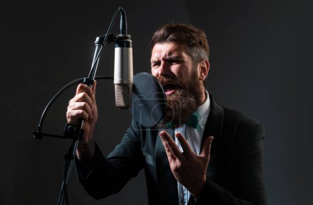 Téléchargez les photos : Music festival. Singer performing a song with a microphone while recording in a music studio - en image libre de droit