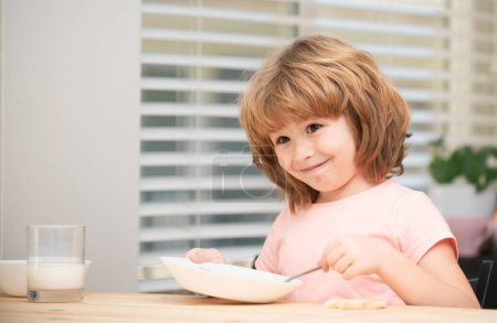 Photo for Child eating healthy food at home. Baby eat soup with spoon - Royalty Free Image