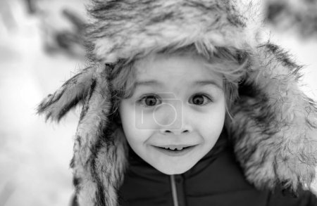 Photo for Winter kid excited face close up. Happy winter time. Happy child playing with snow on a snowy winter walk - Royalty Free Image