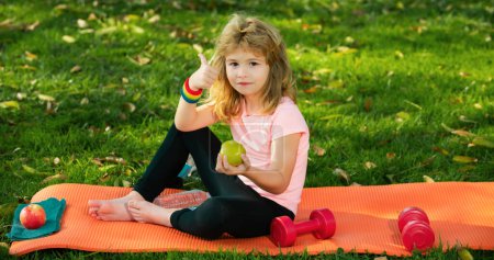 Photo for Healthy eating and healthy lifestyle in children, boy teenager after sports sitting on sport mat drinking water and eating apples. Healthy kids lifestyle - Royalty Free Image