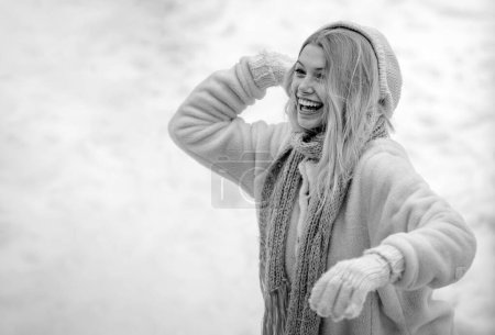 Photo for Winter woman. Cute playful young woman outdoor enjoying first snow. Happy young girl playing snowball fight. Girl in mittens hold snowball - Royalty Free Image