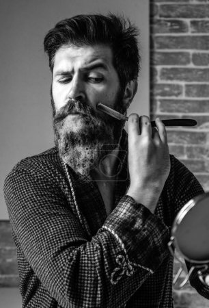 Foto de Hombre visitando peluquero en peluquería. Recortes. Él está haciendo estilo con la máquina de afeitar. Afeitado y afeitado afilado. Navaja de afeitar peluquero. Peluquería - Imagen libre de derechos