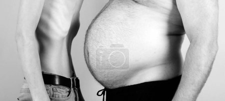 Foto de Hombre obeso cintura grasa corporal. Hombre con figura gorda y delgada sobre fondo amarillo. Anorexia vs problema de grasa - Imagen libre de derechos