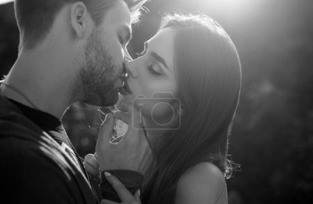 Téléchargez les photos : Un homme avec des baisers de femme. Gros plan portrait d'un beau jeune couple attendant de s'embrasser contre la lumière du coucher du soleil - en image libre de droit