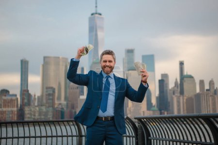 Photo for Excited Businessman hold dollar banknote over New York City. Dollar notes concept. Credit and loan in USA. American finance. Businessman hold hundred dollar banknotes outdoor. Celebrating the success - Royalty Free Image