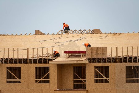 Photo for House roof. Roofing construction. Roofer using air nail. Roofing tiles of the new roof under construction building. Repairing building roof. Repair roofs, install roofing, renovate house. Frames roof - Royalty Free Image