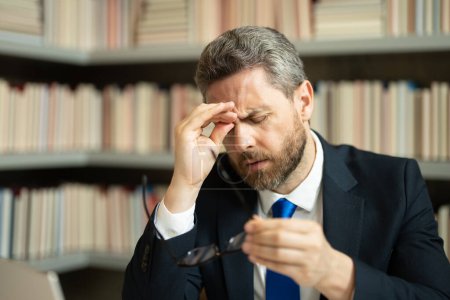Téléchargez les photos : Gros plan portrait d'un homme stressé avec migraine. Maux de tête, fatigue et stress. Homme d'affaires en costume utilise un ordinateur portable, est fatigué a mal à la tête migraine. Douleurs céphalées concept - en image libre de droit