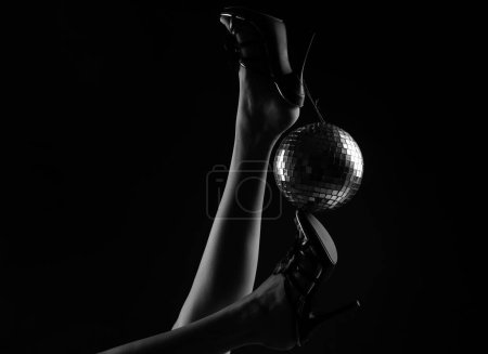 Photo for Celebrating. Disco ball on high heels. Party legs. Holidays event. Woman heels with gold disco ball. Celebrate concept - Royalty Free Image