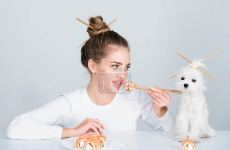 Foto de Estilo sushi japonés. Mujer sexy de belleza comiendo sushi. Rollos de sushi, sashimi. Chica modelo de moda comiendo Sushi con palillos. Corte de pelo con palillos, comer comida japonesa saludable - Imagen libre de derechos