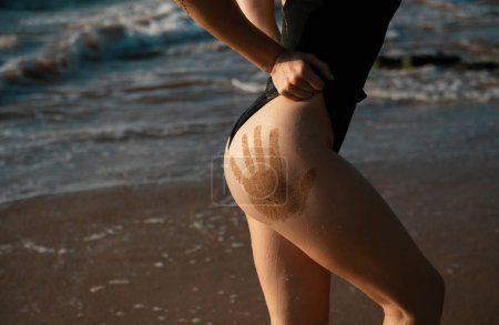 Foto de Swimsuit female model. Womens ass with beauty ass and butt on sea beach. Sex temptation for men. Ideal womans butt and hips - Imagen libre de derechos