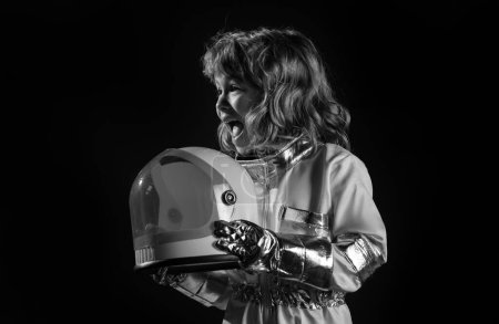 Photo for Portrait of wondered amazed little astronaut in helmet and protective space suit on black - Royalty Free Image