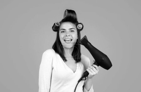 Photo for Funny woman with hair dryer. Beautiful girl with straight hair drying hair with professional hairdryer. Hairdressing concept - Royalty Free Image