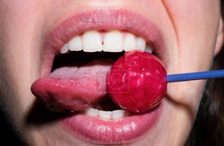 Photo for Licking tongue lips. Sexual lips with candy, sexy sweet dreams. Female mouth licks chupa chups, sucks lollipop - Royalty Free Image