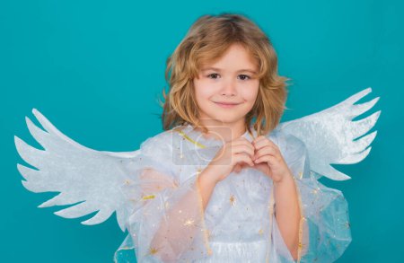Photo for Kid wearing angel costume white dress and feather wings. Innocent child. Little angel on isolated studio background - Royalty Free Image