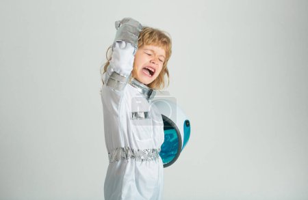 Téléchargez les photos : Petit garçon excité portant un costume de casque d'astronaute et. Enfant mignon en astronaute jouant et rêvant de devenir un astronaute - en image libre de droit