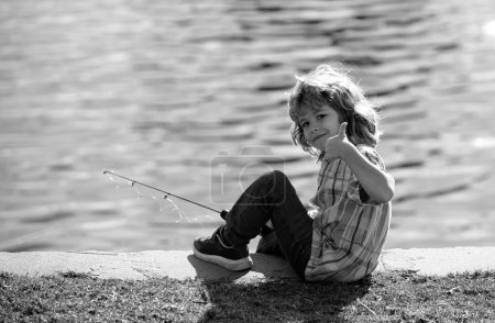 Photo for Happy childhood. Child fishing on the lake. Young fisher. Boy with spinner at river. Portrait of excited boy fishing. Boy at jetty with rod. Fishing concept - Royalty Free Image