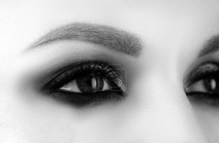 Foto de Primer plano ojos de maquillaje ahumado párpados oscuros. Ojos femeninos con hermoso estilo de moda brillante - Imagen libre de derechos