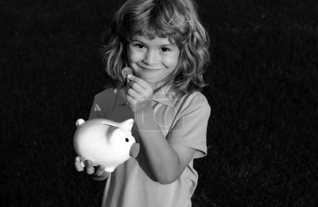 Photo for Piggy bank and little boy with coin. Baby child putting a coin into a moneybox piggy bank, kid saving money for future concept - Royalty Free Image