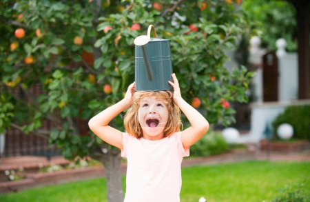 Téléchargez les photos : Drôles excités enfants eaux plantes dans le jardin arrière-cour avec arrosoir - en image libre de droit