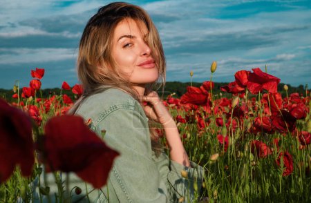 Téléchargez les photos : Portrait d'une belle femme au printemps champ de fleurs de pavot. Fille heureuse reposant sur un beau champ de pavot - en image libre de droit