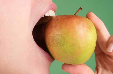 Téléchargez les photos : Des dents blanches saines se referment avec une pomme. Soins dentaires. Dents humaines - en image libre de droit