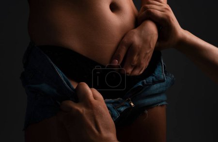 Foto de Una mujer tocándose. Hombre desnudando joven sensual mujer con vientre desnudo. Quitando sexy de las mujeres lencería - Imagen libre de derechos