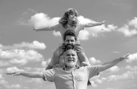 Photo for Generational famil. Father, son and grandfather happy multi genration family with raising hands or open arms flying on sky - Royalty Free Image