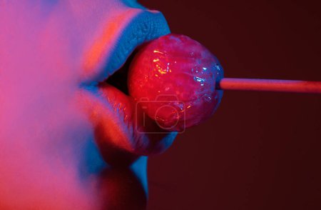 Photo for Sexual lips with candy, sexy sweet dreams. Oral sex blow job concept. Female mouth licks chupa chups, sucks lollipop. Neon lights. Night club background - Royalty Free Image