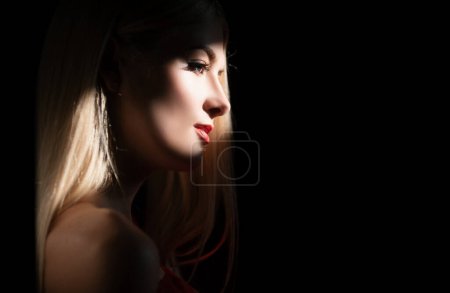 Photo for Beautiful young woman portrait on black. Sensual face of elegant female model in studio. Elegant lady. Creative portraits with shadow and light over womans face, eyes on light - Royalty Free Image
