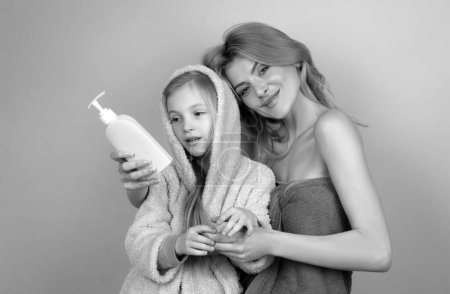 Téléchargez les photos : Équipement d'hygiène pour enfants. L'heure du bain. Mère avec fille dans la salle de bain. Savon liquide, accessoire pour bain, douche et soins de santé - en image libre de droit