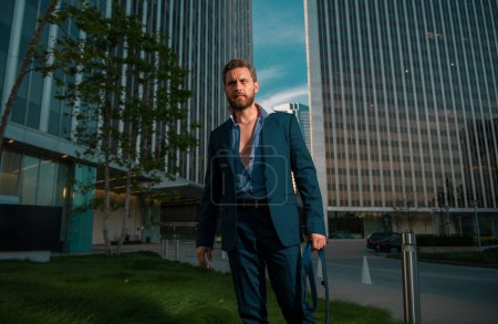Téléchargez les photos : Homme d'affaires caucasien en costume sort bureau. concept de fin de journée de travail. Homme d'affaires sexy mode - en image libre de droit