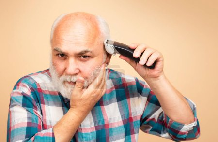 Photo for Portrait of old man being trimmed with hair clipper in barbershop, haircut with an electric razor. Man hair treatment - Royalty Free Image