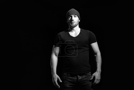 Téléchargez les photos : Un bel homme porte un t-shirt noir. Studio portrait de mode - en image libre de droit
