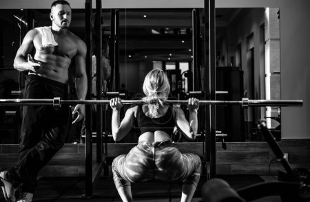 Photo for Young sporty couple workout with barbell in gym. Muscular trainer man training woman Personal trainer fitness instructor - Royalty Free Image