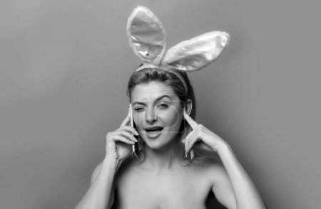 Photo for Funny Easter bunny woman calling with cell phone - Royalty Free Image