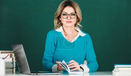 Téléchargez les photos : Portrait d'une enseignante ou d'une femme d'affaires travaillant à table au collège ou au lycée. Jeunes étudiantes en classe - en image libre de droit