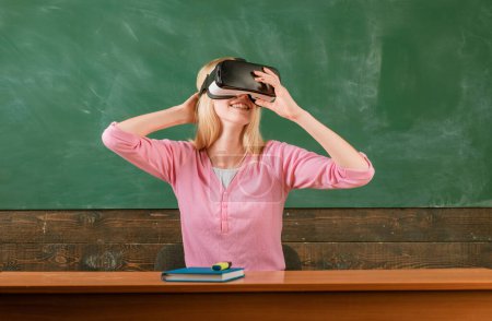 Photo for Student reading with VR glasses on a blackboard. School girl with virtual reality headset. Education in high school university college with future education technology - Royalty Free Image