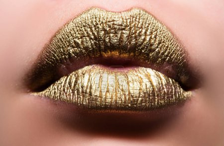 Téléchargez les photos : Des lèvres d'or. Femme wouth fermer avec rouge à lèvres de couleur dorée sur la lèvre. Glitter lèvres brillantes mordant - en image libre de droit